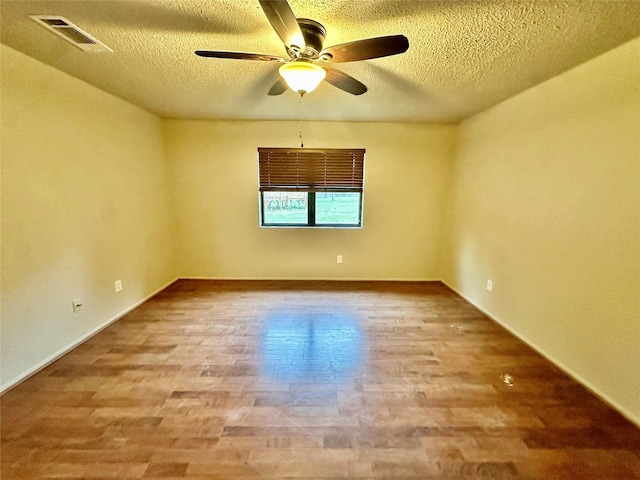 677 County Road 3081, Lampasas, TX 76550 - unfurnished room with a ceiling fan, wood finished floors, a textured ceiling, and baseboards