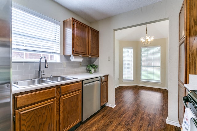 905 Wildwood Cir, Grapevine, TX 76051 - kitchen with appliances with stainless steel finishes, a sink, dark wood-type flooring, brown cabinets, and a textured ceiling