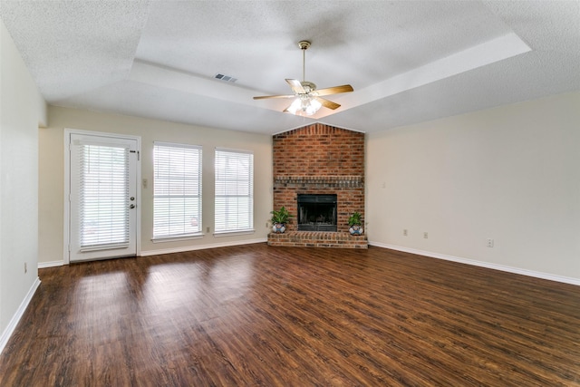 905 Wildwood Cir, Grapevine, TX 76051 - unfurnished living room featuring a raised ceiling, ceiling fan, dark wood-style flooring, a textured ceiling, and baseboards