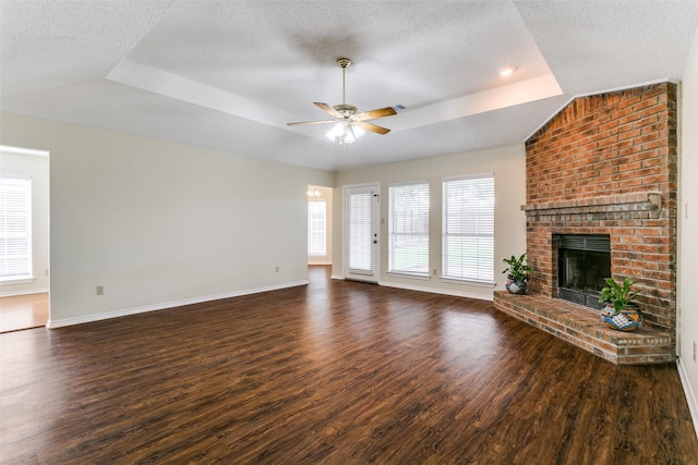 905 Wildwood Cir, Grapevine, TX 76051 - unfurnished living room with a tray ceiling, a ceiling fan, dark wood-type flooring, a textured ceiling, and baseboards