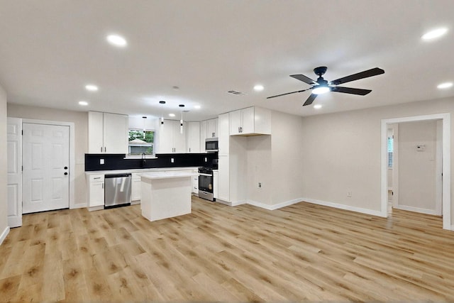 3103 Andrea Ln, Dallas, TX 75228 - kitchen featuring stainless steel appliances, recessed lighting, a center island, baseboards, and white cabinets