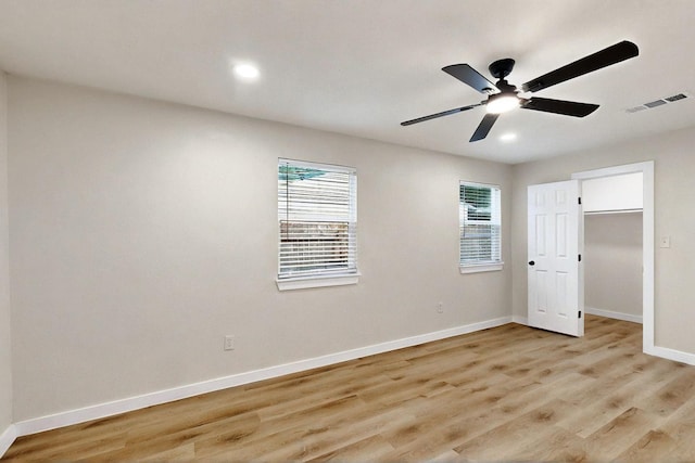 3103 Andrea Ln, Dallas, TX 75228 - unfurnished bedroom with multiple windows, light wood-type flooring, recessed lighting, ceiling fan, and a walk in closet