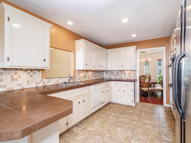 905 High Rd, Coleman, TX 76834 - kitchen featuring dishwasher, a sink, a chandelier, tasteful backsplash, and white cabinets
