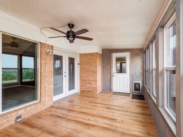 905 High Rd, Coleman, TX 76834 - unfurnished sunroom featuring french doors, a textured ceiling, wood finished floors, and brick wall
