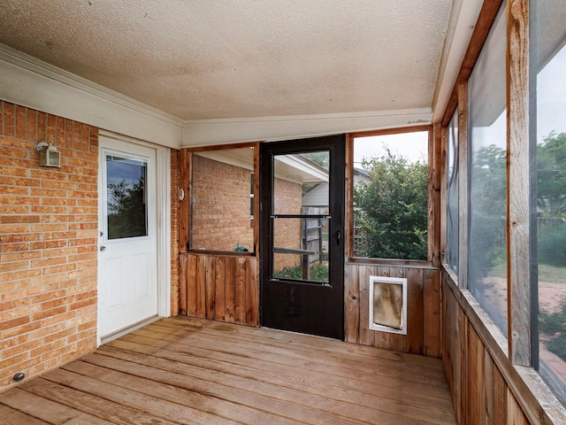 905 High Rd, Coleman, TX 76834 - unfurnished sunroom with a textured ceiling, wood finished floors, brick wall, and plenty of natural light