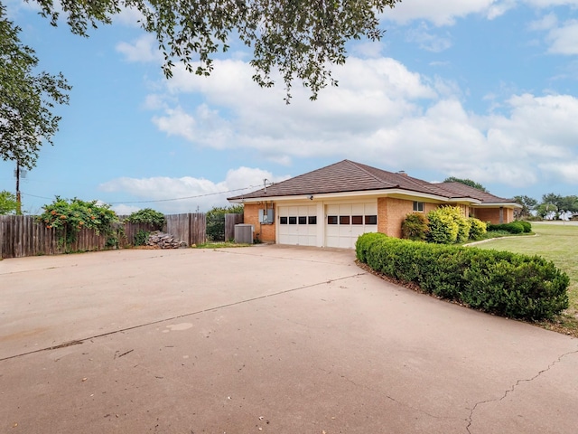 905 High Rd, Coleman, TX 76834 - view of home's exterior with an attached garage, brick siding, central AC unit, and concrete driveway