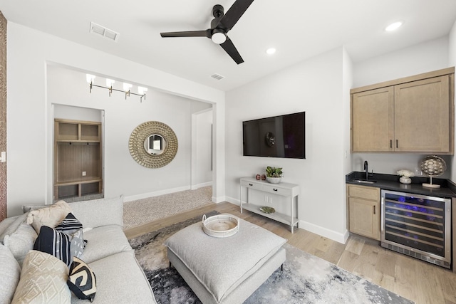 1015 Olympic Dr, Rockwall, TX 75087 - living room featuring beverage cooler, wet bar, ceiling fan, light wood-style flooring, and baseboards