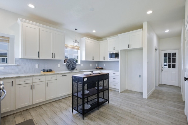 21 Graham Ln, Lucas, TX 75002 - kitchen featuring stainless steel microwave, backsplash, white cabinets, light wood-style floors, and recessed lighting