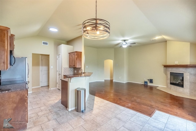 210 Miss Ellie Ln, Abilene, TX 79602 - kitchen with vaulted ceiling, a ceiling fan, arched walkways, a tile fireplace, and open floor plan