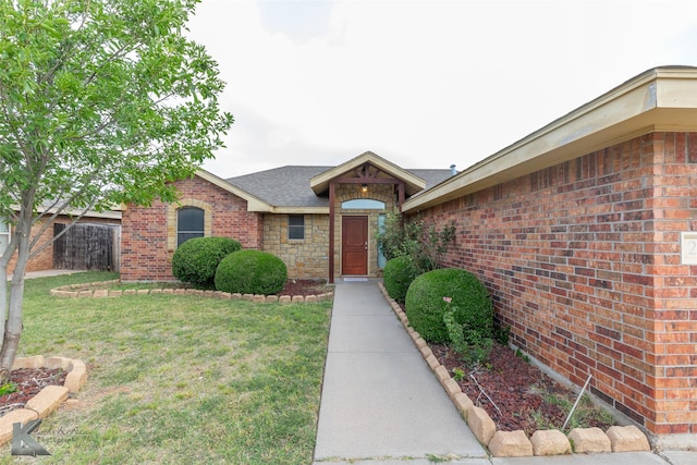 210 Miss Ellie Ln, Abilene, TX 79602 - property entrance featuring a lawn, brick siding, and a shingled roof