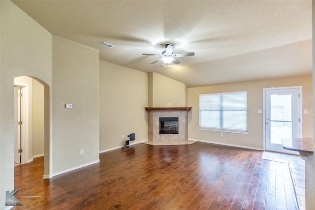 210 Miss Ellie Ln, Abilene, TX 79602 - unfurnished living room with a ceiling fan, arched walkways, a fireplace, vaulted ceiling, and wood finished floors