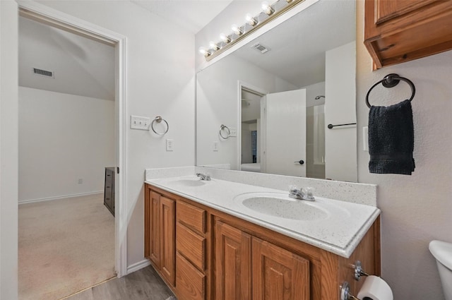 4525 Wheatland Dr, Fort Worth, TX 76179 - bathroom with double vanity, toilet, and wood finished floors