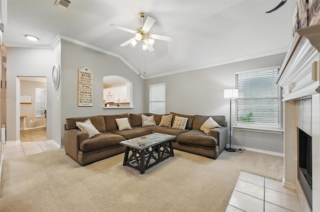 4525 Wheatland Dr, Fort Worth, TX 76179 - living area featuring light colored carpet, a fireplace with flush hearth, a ceiling fan, crown molding, and light tile patterned floors