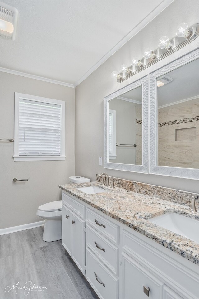 156 Charles Ave, Shreveport, LA 71105 - full bathroom featuring double vanity, ornamental molding, toilet, wood finished floors, and tiled shower