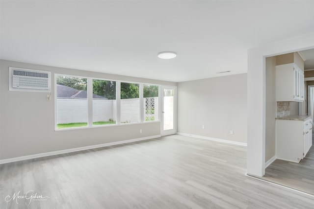 156 Charles Ave, Shreveport, LA 71105 - empty room with a wall unit AC, light wood-style flooring, and baseboards
