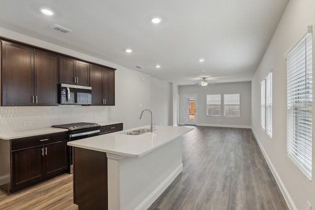 519 Willet Dr, Mckinney, TX 75069 - kitchen featuring stainless steel appliances, a sink, decorative backsplash, a center island with sink, and light countertops
