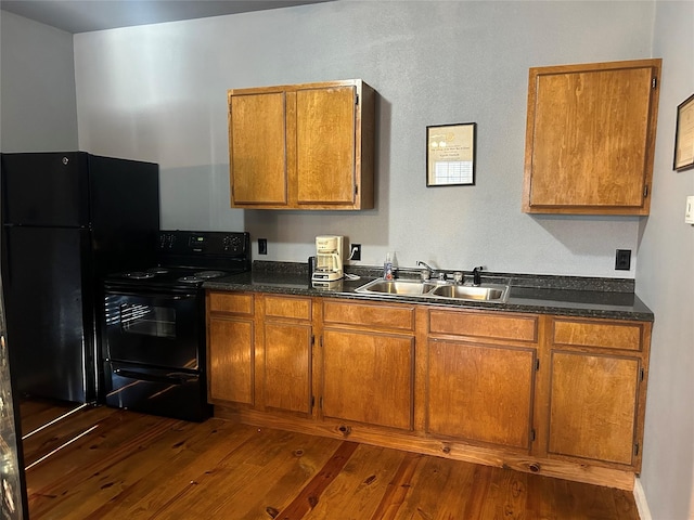 1004 Church St, Sulphur Springs, TX 75482 - kitchen featuring black appliances, a sink, dark wood-type flooring, and brown cabinetry