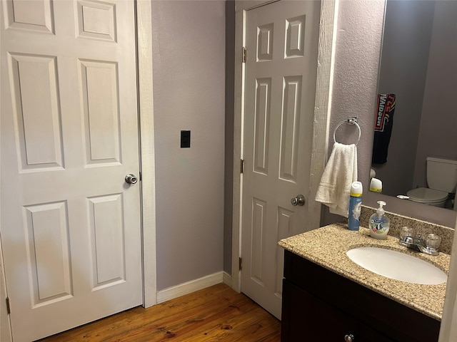 1004 Church St, Sulphur Springs, TX 75482 - half bath with wood finished floors, baseboards, toilet, and vanity