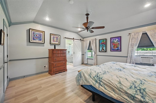 2800 E Fm 4, Cleburne, TX 76031 - bedroom with lofted ceiling, a barn door, a textured ceiling, cooling unit, and light wood finished floors