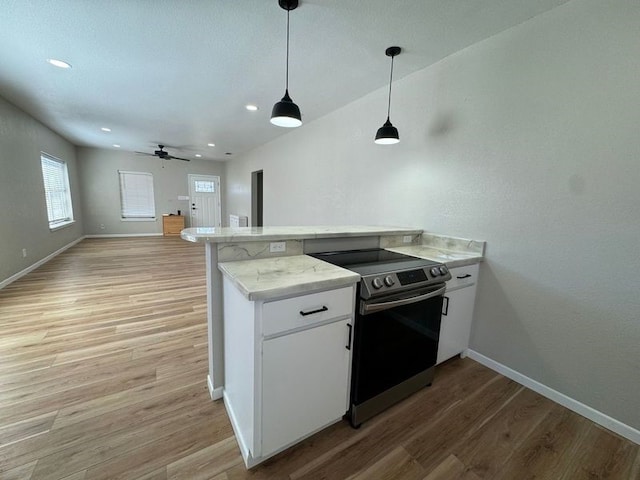 608 S Seaman St, Eastland, TX 76448 - kitchen featuring stainless steel range with electric stovetop, a peninsula, light wood-style flooring, baseboards, and white cabinetry