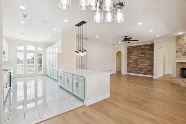 3517 Grants Lndg, Fort Worth, TX 76179 - kitchen with a chandelier, a fireplace, arched walkways, open floor plan, and a ceiling fan