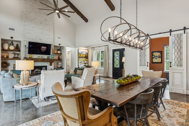 7404 Sandy Lake Rd, Quinlan, TX 75474 - dining space featuring high vaulted ceiling, a barn door, ceiling fan, a chandelier, and a fireplace