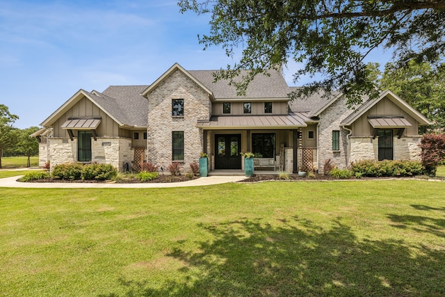 7404 Sandy Lake Rd, Quinlan, TX 75474 - view of front facade featuring board and batten siding, a standing seam roof, a front yard, and stone siding
