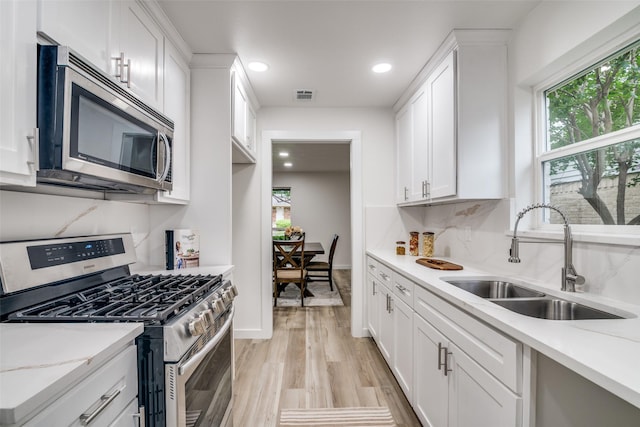 1106 Spring Lake Dr, Garland, TX 75043 - kitchen featuring appliances with stainless steel finishes, a sink, white cabinets, and recessed lighting