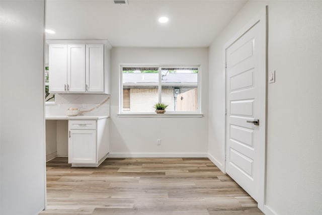 1106 Spring Lake Dr, Garland, TX 75043 - kitchen with white cabinets, light wood finished floors, recessed lighting, baseboards, and light countertops