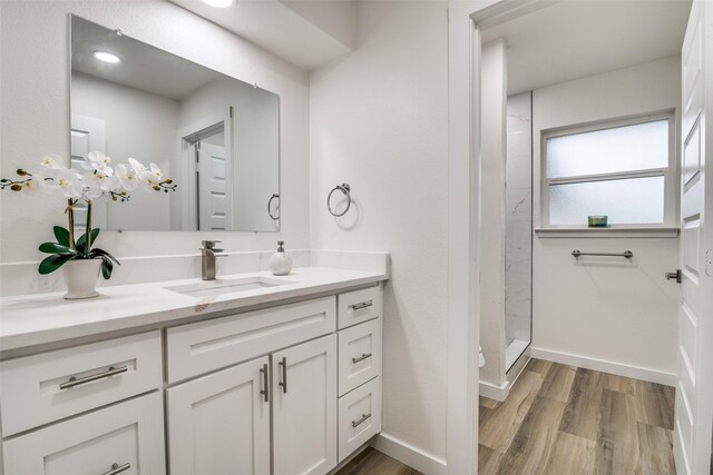 1106 Spring Lake Dr, Garland, TX 75043 - bathroom with wood finished floors, vanity, a shower stall, and baseboards