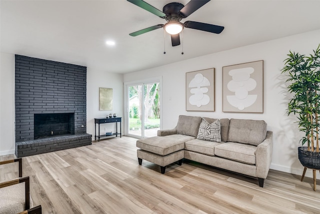1106 Spring Lake Dr, Garland, TX 75043 - living area with light wood finished floors, ceiling fan, a fireplace, and baseboards