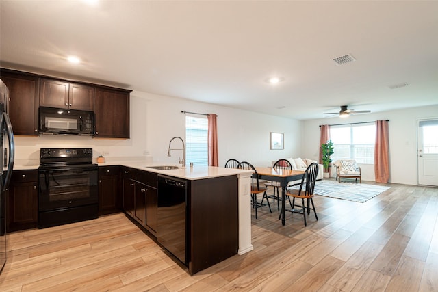 723 Cochran Dr, Princeton, TX 75407 - kitchen featuring black appliances, a sink, a peninsula, dark brown cabinetry, and light wood-style flooring