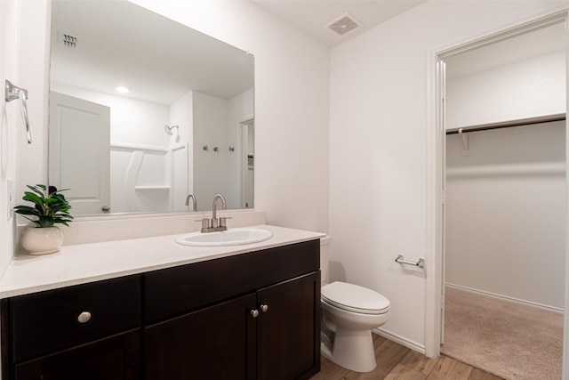 723 Cochran Dr, Princeton, TX 75407 - full bath featuring wood finished floors, toilet, a shower, vanity, and a spacious closet