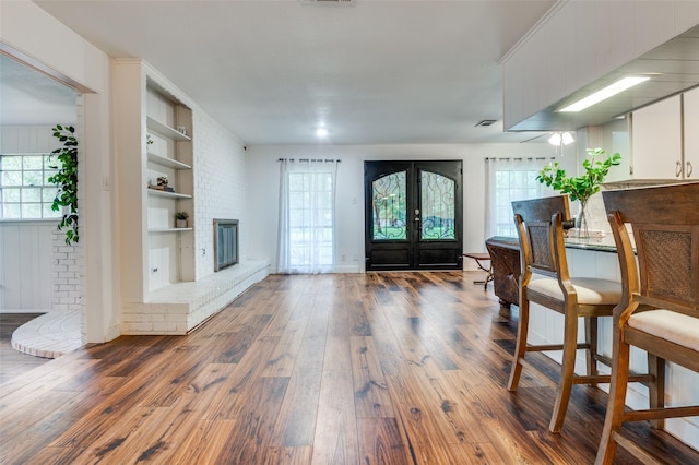 606 Quiram Ln, Kemp, TX 75143 - foyer entrance with french doors, hardwood / wood-style flooring, and a brick fireplace