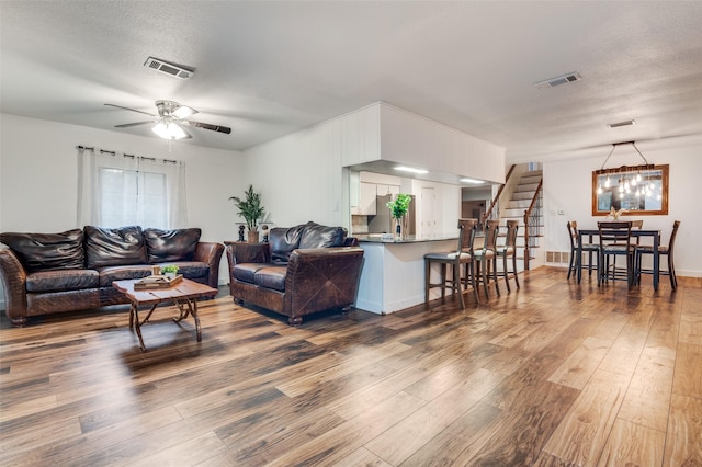 606 Quiram Ln, Kemp, TX 75143 - living area featuring wood-type flooring, a chandelier, ceiling fan, and stairs