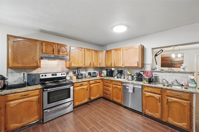 407 Mckinley St, Cedar Hill, TX 75104 - kitchen featuring stainless steel appliances, under cabinet range hood, a sink, tasteful backsplash, and dark wood-type flooring