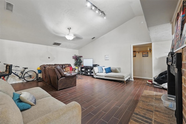 407 Mckinley St, Cedar Hill, TX 75104 - living room with lofted ceiling, a fireplace with raised hearth, ceiling fan, dark wood-style flooring, and baseboards