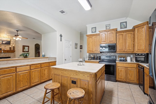 568 Willowview Dr, Saginaw, TX 76179 - kitchen featuring appliances with stainless steel finishes, arched walkways, light tile patterned floors, light countertops, and crown molding