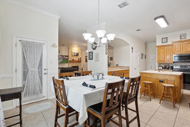 568 Willowview Dr, Saginaw, TX 76179 - dining space with light tile patterned floors, a chandelier, crown molding, and arched walkways
