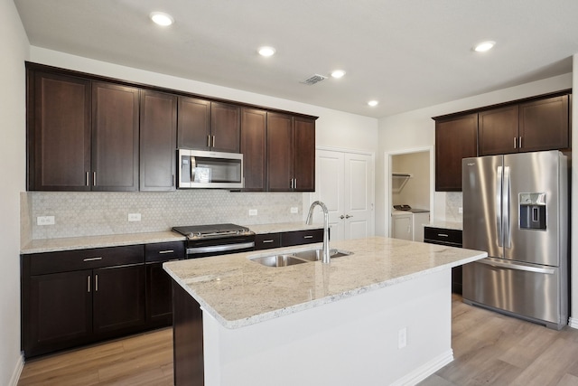 511 Willet Dr, Mckinney, TX 75069 - kitchen featuring appliances with stainless steel finishes, independent washer and dryer, a sink, light wood-type flooring, and recessed lighting