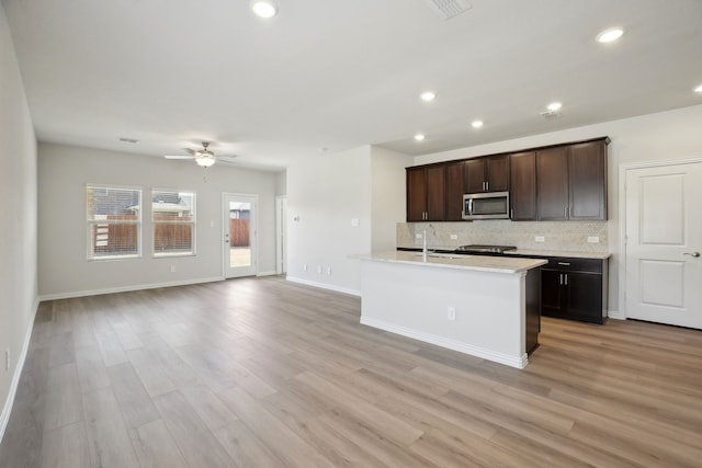 511 Willet Dr, Mckinney, TX 75069 - kitchen with stainless steel microwave, a sink, tasteful backsplash, ceiling fan, and light wood finished floors