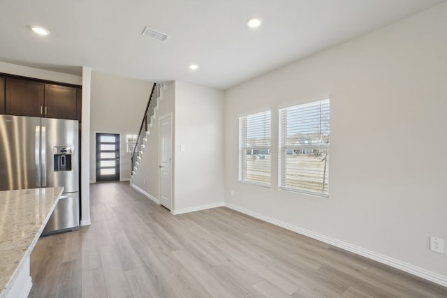 511 Willet Dr, Mckinney, TX 75069 - kitchen with stainless steel fridge with ice dispenser, dark brown cabinetry, light stone counters, light wood-style flooring, and baseboards