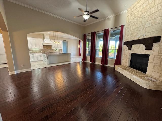 2802 Castlereach St, Trophy Club, TX 76262 - unfurnished living room featuring a ceiling fan, a fireplace, wood-type flooring, and crown molding