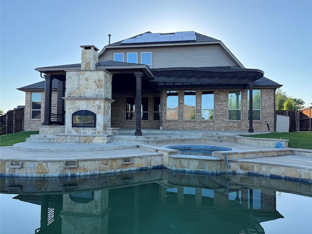 2802 Castlereach St, Trophy Club, TX 76262 - rear view of house with roof mounted solar panels, a chimney, an in-ground hot tub, and brick siding