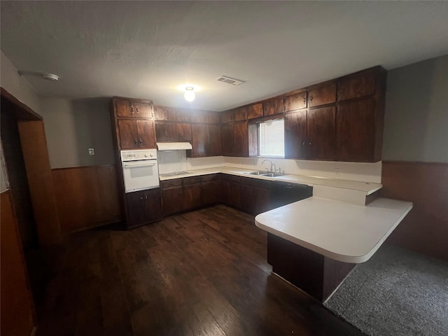 101 Oakland Dr, Lacy Lakeview, TX 76705 - kitchen with oven, a peninsula, light countertops, dark wood-style flooring, and under cabinet range hood