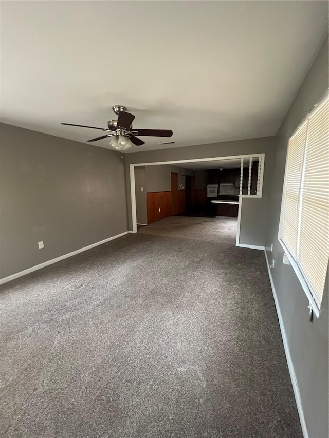 101 Oakland Dr, Lacy Lakeview, TX 76705 - unfurnished living room featuring ceiling fan, baseboards, and dark colored carpet