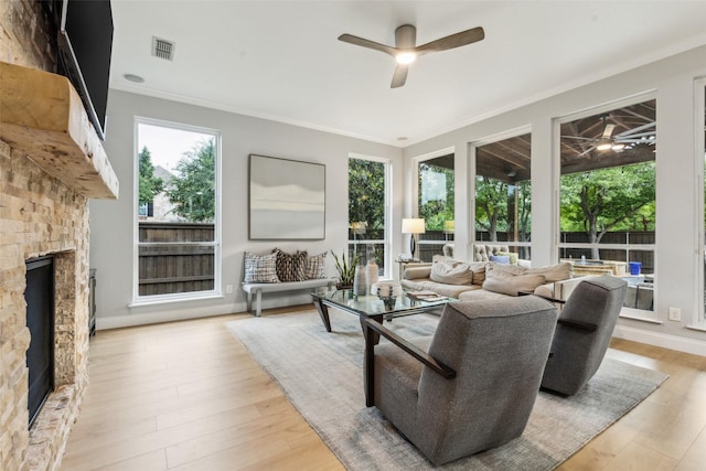 5213 Evening Sun Dr, Frisco, TX 75034 - living area featuring ceiling fan, a fireplace, crown molding, and light wood finished floors