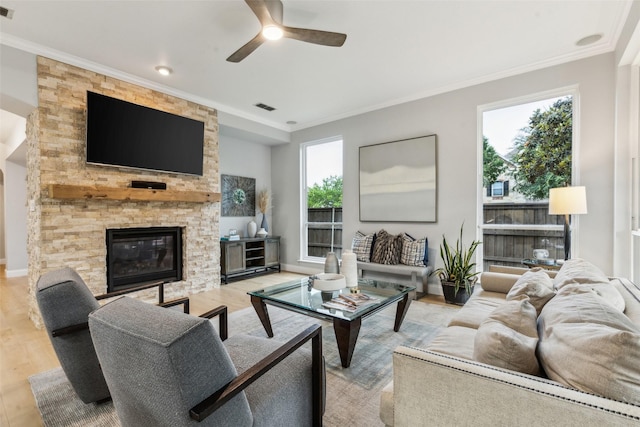 5213 Evening Sun Dr, Frisco, TX 75034 - living area featuring ceiling fan, ornamental molding, wood finished floors, a stone fireplace, and baseboards
