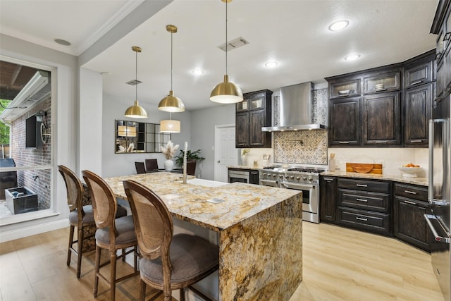 5213 Evening Sun Dr, Frisco, TX 75034 - kitchen with wall chimney range hood, range with two ovens, light wood-style flooring, decorative backsplash, and recessed lighting