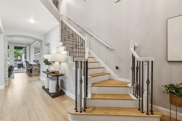 5213 Evening Sun Dr, Frisco, TX 75034 - staircase with arched walkways, wood finished floors, and baseboards